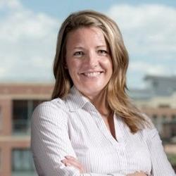 Woman with long blonde hair crossing arms and smiling