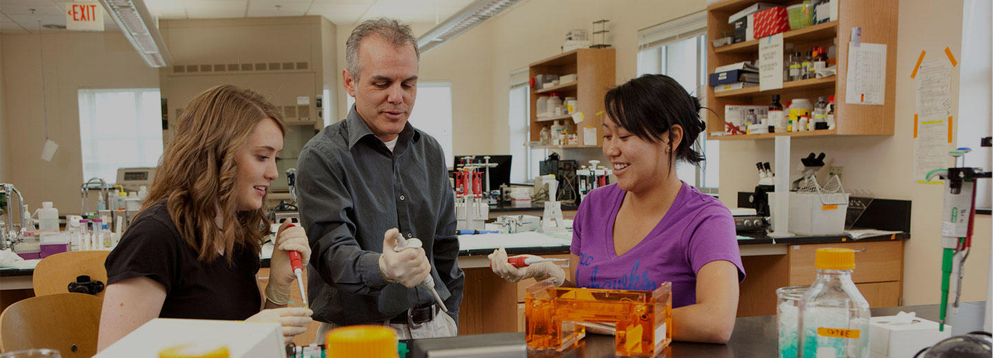 Biology Teacher Assisting Two Students